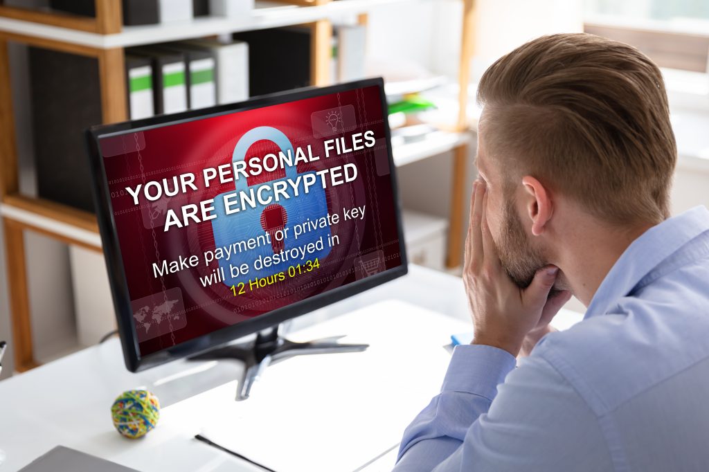 Worried,Businessman,Looking,At,Computer,With,Ransomware,Word,On,The